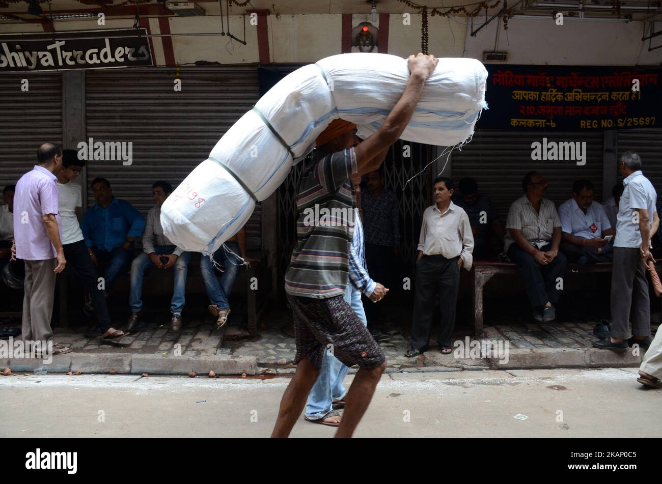 Ein indischer Arbeiter, der Waren transportiert, geht am Donnerstag, 29.. Juni 2017, während des Streiks gegen GST in Kalkutta, Indien, am geschlossenen Laden in Burrabazar vorbei. Tuchhändler gehen ab 27. Juni zu einem dreitägigen landesweiten Streik, um gegen 5 Prozent GST (Waren- und Dienstleistungssteuer) zu protestieren, die auf die von ihnen erbrachten Dienstleistungen (Arbeitsleistungen) für die Textilindustrie erhoben werden.Textilhändler protestieren gegen eine komplexe, verwirrende GST (Waren- und Dienstleistungssteuer) Regeln im ganzen Land. (Foto von Sonali Pal Chaudhury/NurPhoto) *** Bitte nutzen Sie die Gutschrift aus dem Kreditfeld *** Stockfoto