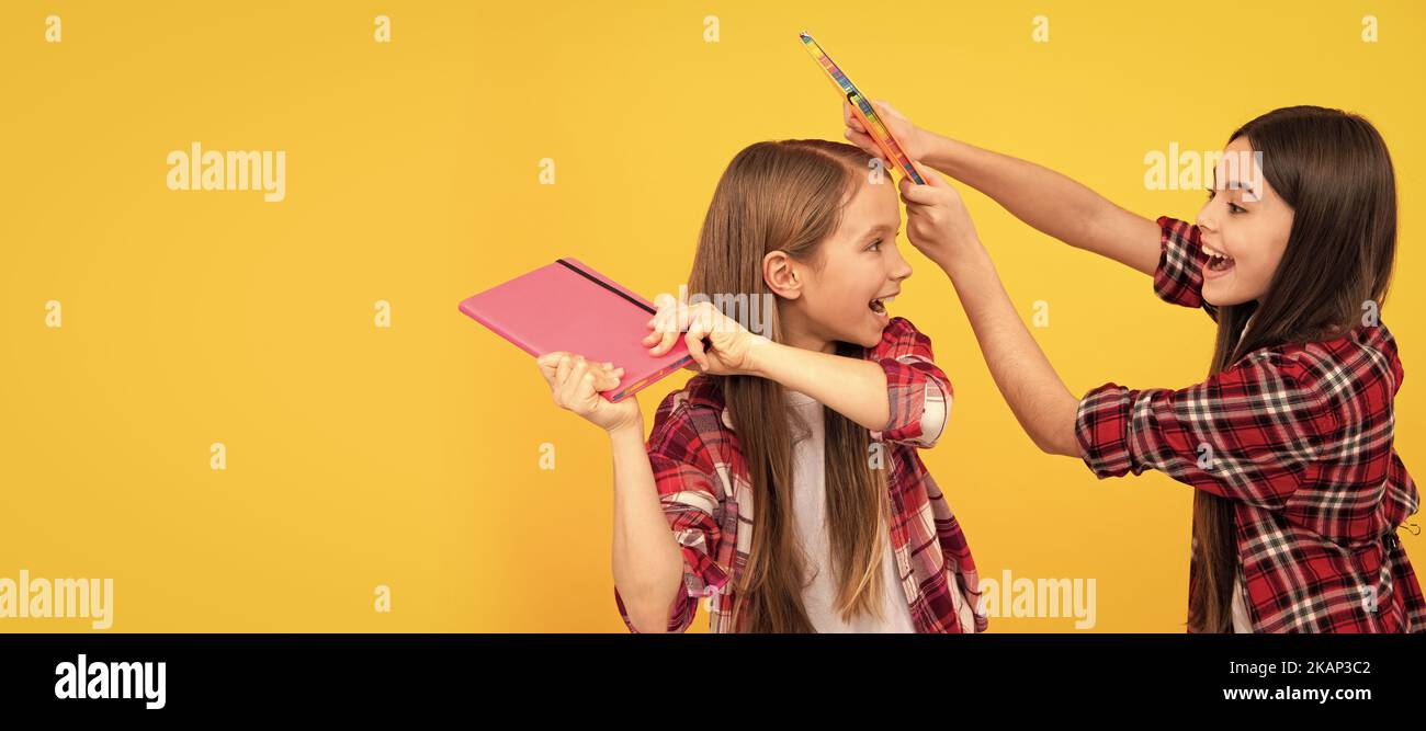 Schulmädchen Freunde. Glückliche Teenager-Mädchen im karierten Shirt spielen mit Notebooks, positive Emotionen. Porträt einer Schülerin, Studiobanner Stockfoto