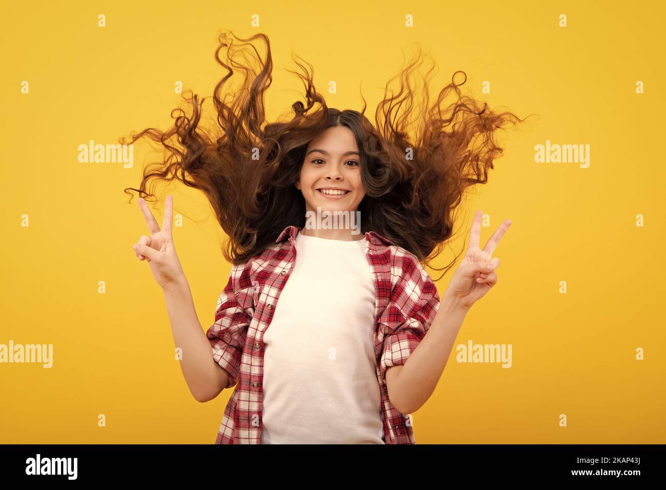 Glücklicher Teenager, positive und lächelnde Emotionen des Teenagers. Teenager Gesicht mit verrückten Bewegung Haare. Junge Teenager-Kind mit fließenden Haaren. Brünette teen Stockfoto