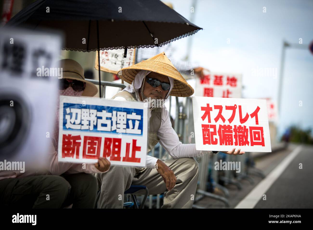 Anti-US-Demonstranten mit ihren Plakaten veranstalten am 13. Juli 2017 in Henoko, Nago, Präfektur Okinawa, Japan, eine Kundgebung vor dem Tor von Camp Schwab, um gegen den Bau des neuen US-Marinestützpunktes zu protestieren. Die Demonstranten skandierten Slogans gegen die Pläne und hielten Plakate mit der Anprangerung der US-Militärpräsenz, als sie die Straße zum Marinebasis in Henoko säumten. (Foto von Richard Atrero de Guzman/NURPhoto) (Foto von Richard Atrero de Guzman/NurPhoto) *** Bitte nutzen Sie die Gutschrift aus dem Kreditfeld *** Stockfoto