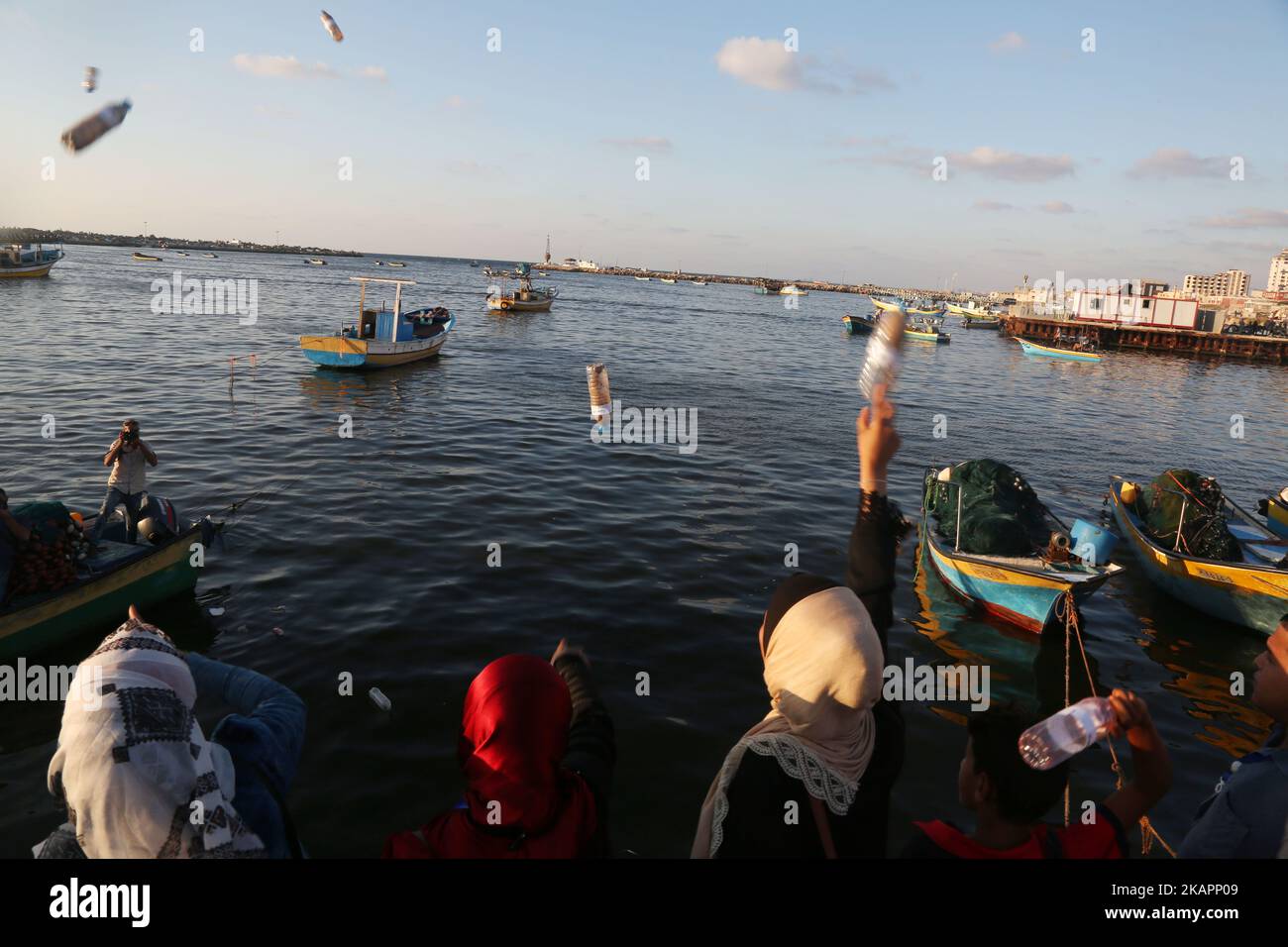 Palästinensische Aktivisten werfen am 22. August 2017 im Hafen von Gaza-Stadt Flaschen ins Meer mit Botschaften gegen die Belagerung des Gazastreifens. Die Initiative entstand, nachdem ein palästinensischer Fischer eine Nachricht in einer Flasche, die von einem britischen Ehepaar auf der Insel Rhodos ins Meer geworfen wurde, gefunden hatte, nachdem sie im Gazastreifen ausgespült worden war. (Foto von Majdi Fathi/NurPhoto) Stockfoto