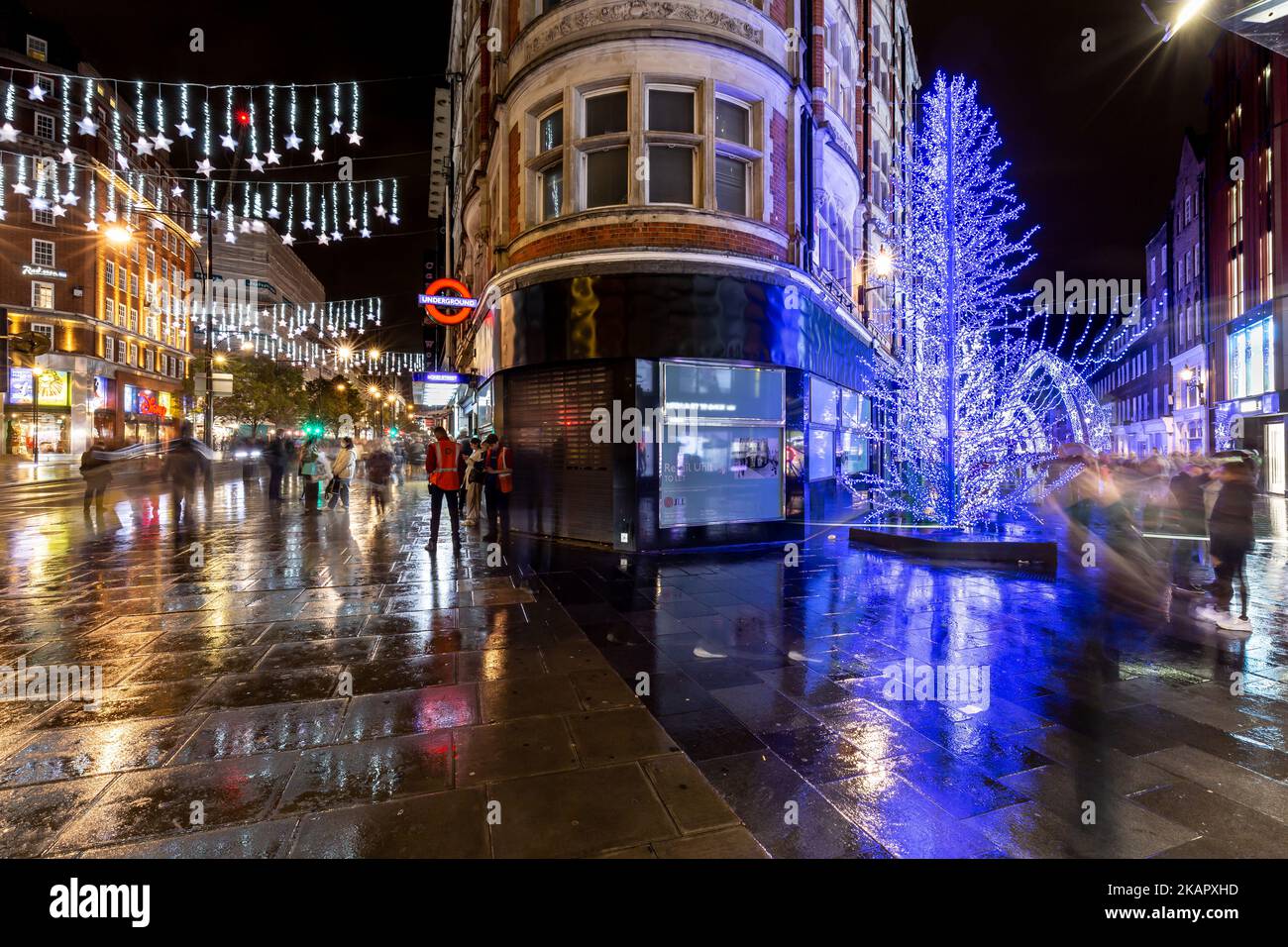 Weihnachtsbeleuchtung an der Ecke von oxford und South Molten Streets.Blue christmas Displays reflektiert in den nassen Bürgersteigen.Xmas 2022 Stockfoto