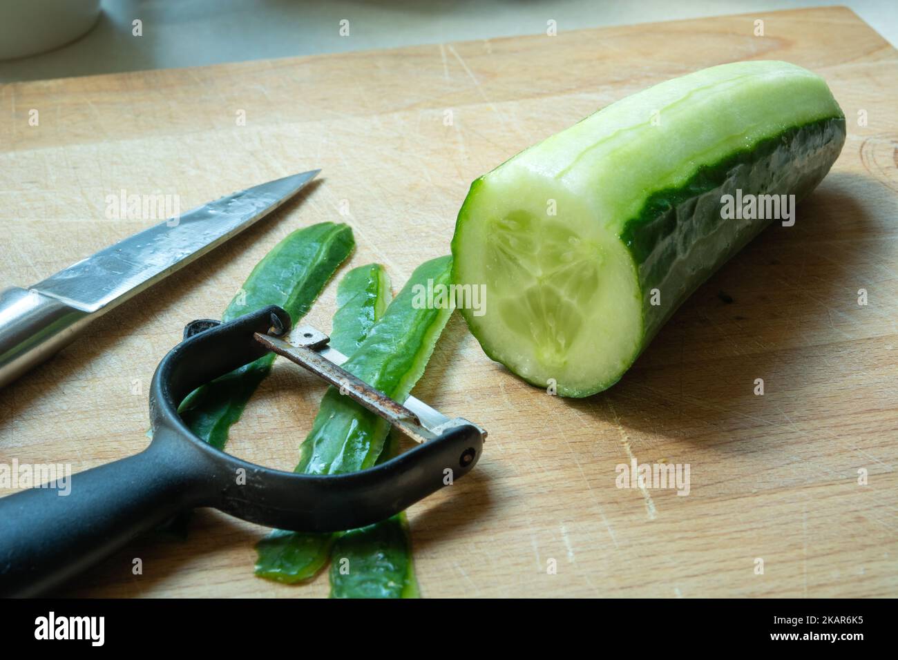 Eine Nahaufnahme von Küchenzubehör zum Schälen von grüner Gurke Stockfoto