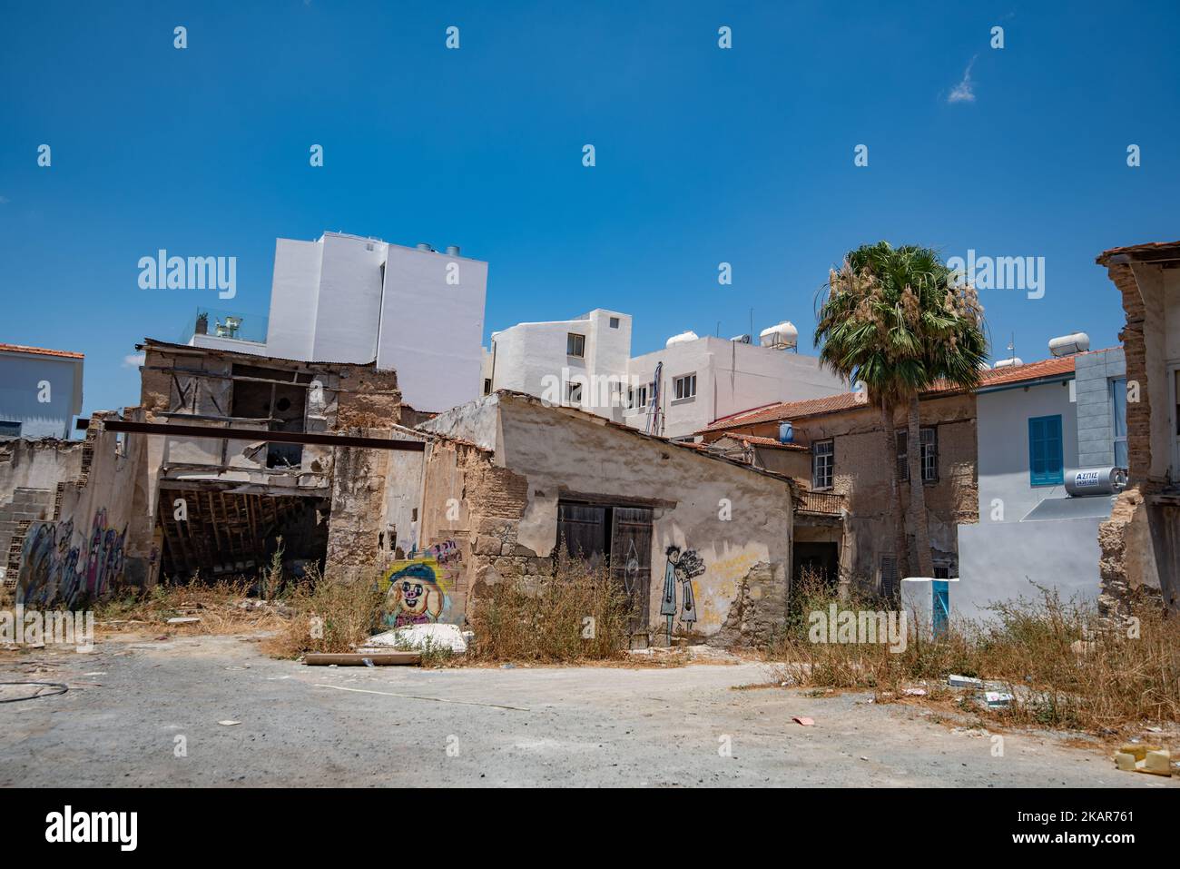 Eine Außenansicht von alten verlassenen Gebäuden mit neuen im Hintergrund in Zypern Stockfoto