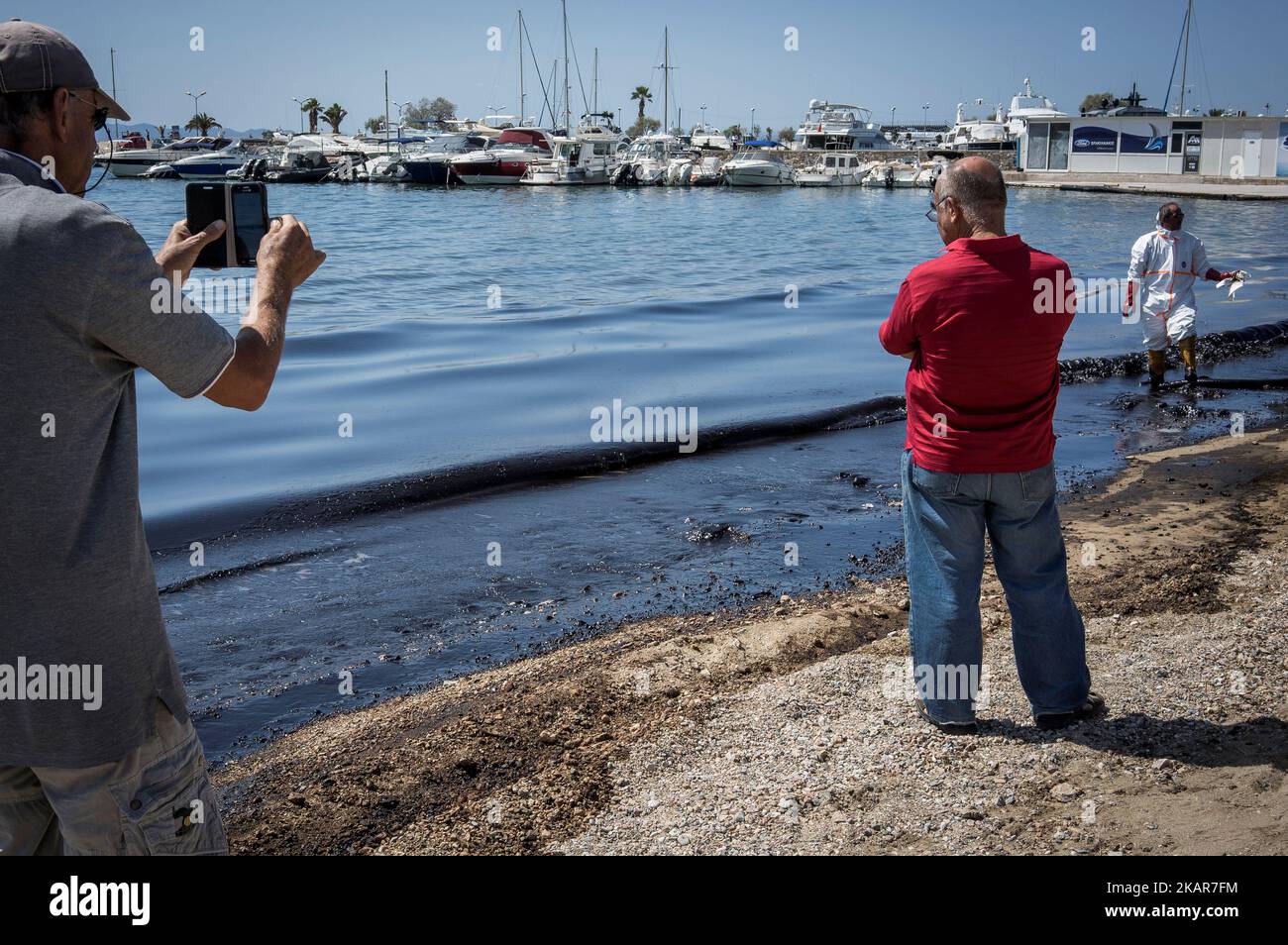 Stadtarbeiter versuchen zusammen mit Freiwilligen, die Ölpest des griechischen Tankers Agia Zoni II, der vor der Insel Salamis an den Stränden von Glyfada und anderen Teilen der Riviera von Athen versank, einzudämmen. Athen, Den 14. September 2017. Der kleine Tanker 'Agia Zoni II' sank am 10. September, während er vor der Küste von Salamis in der Nähe des griechischen Haupthafens Piräus vor Anker ging. Es trug eine Ladung von 2.200 Tonnen Heizöl und 370 Tonnen Meeresgasöl. Die Insel Salamis wurde durch eine von Beamten so genannte „große Umweltkatastrophe“ stark verschmutzt. (Foto von Kostis Ntanta Stockfoto