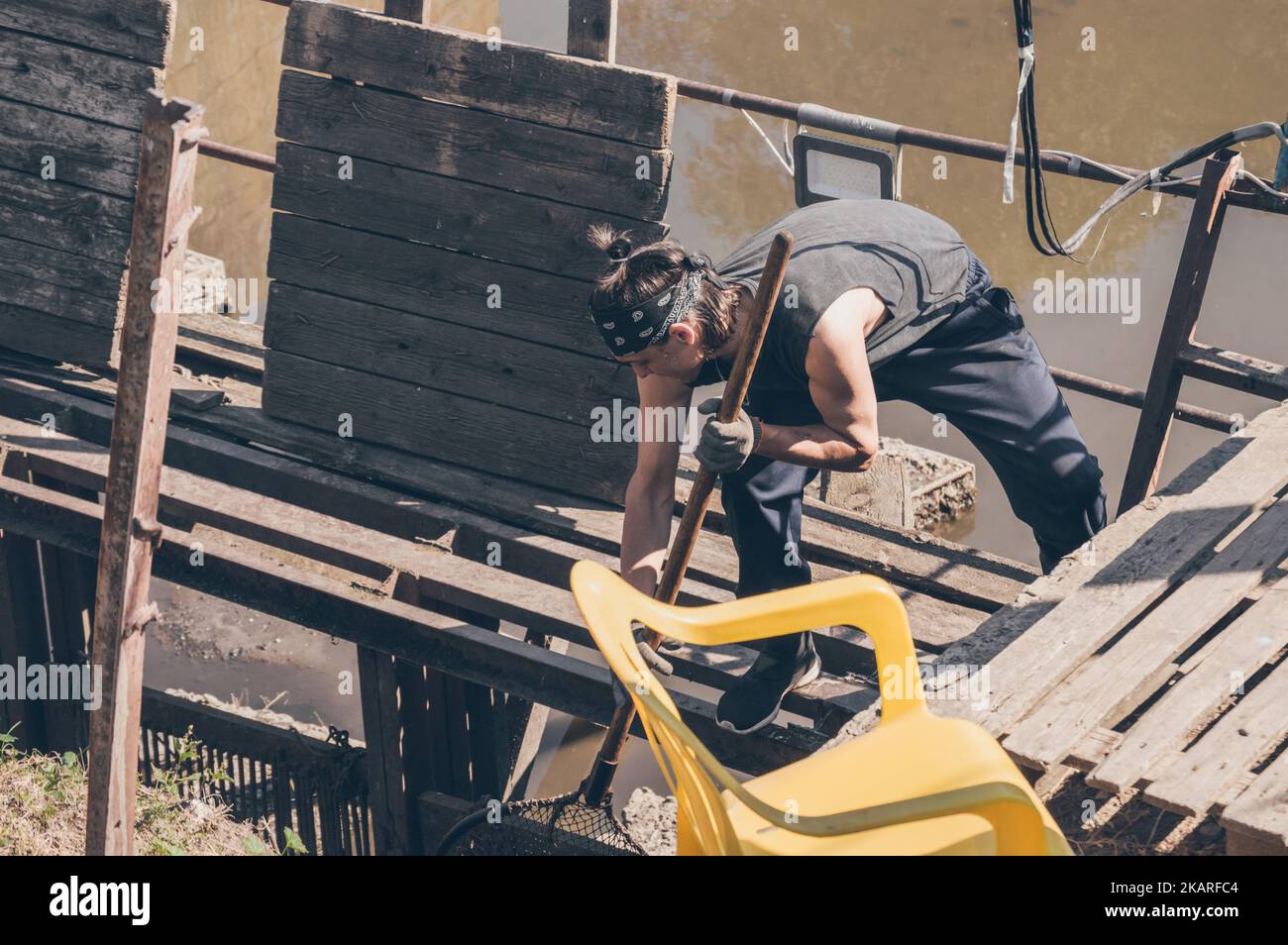 Junger Fischer mit Netz arbeitet in der Fischerei Stockfoto