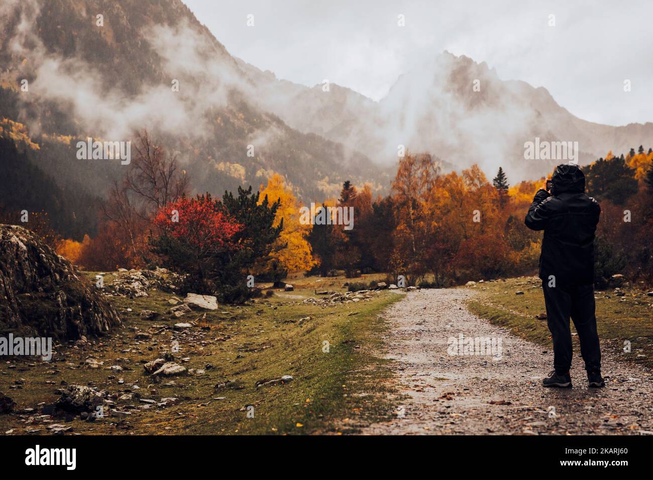 Junge von hinten fotografiert eine Berglandschaft Stockfoto