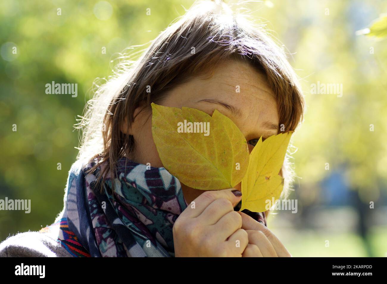 Eine Frau geht an einem Herbsttag im Park spazieren Stockfoto