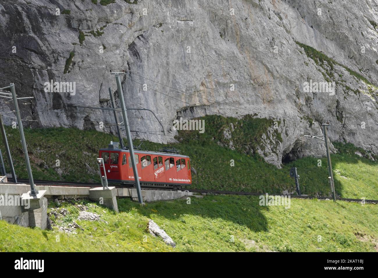 Rote Zahnradbahn zwischen dem Bahnhof Alpnachstad und dem Berg Pilatus Kulm. Stockfoto