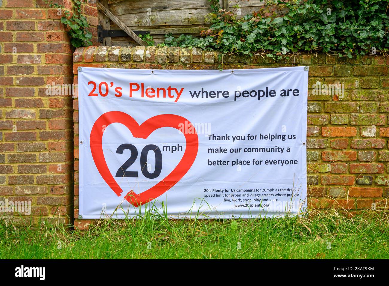 Lokales Community-Banner mit einer Kampagne zur Sensibilisierung für die Geschwindigkeit von 20 km/h, die an einer Backsteinmauer im Dorf Shipley, West Sussex, England, hängt. Stockfoto