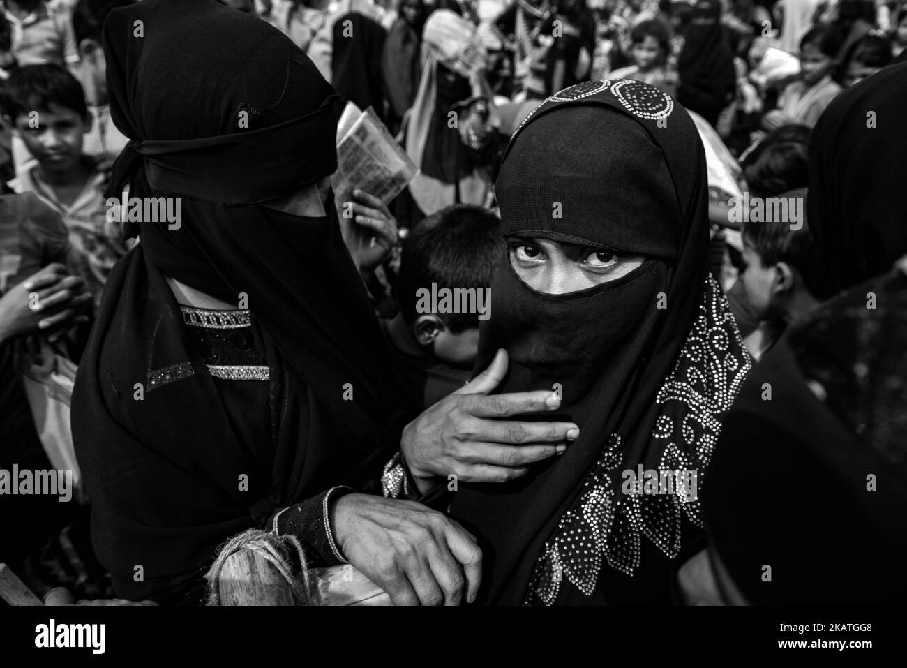 Eine Rohingya-Flüchtlingsfrau und andere warten auf Nahrungsmittelhilfe von einer lokalen NGO im Balukhali-Flüchtlingslager in der Nähe von Cox's Bazar, Bangladesch, 22. November 2017. (Foto von Szymon Barylski/NurPhoto) Stockfoto