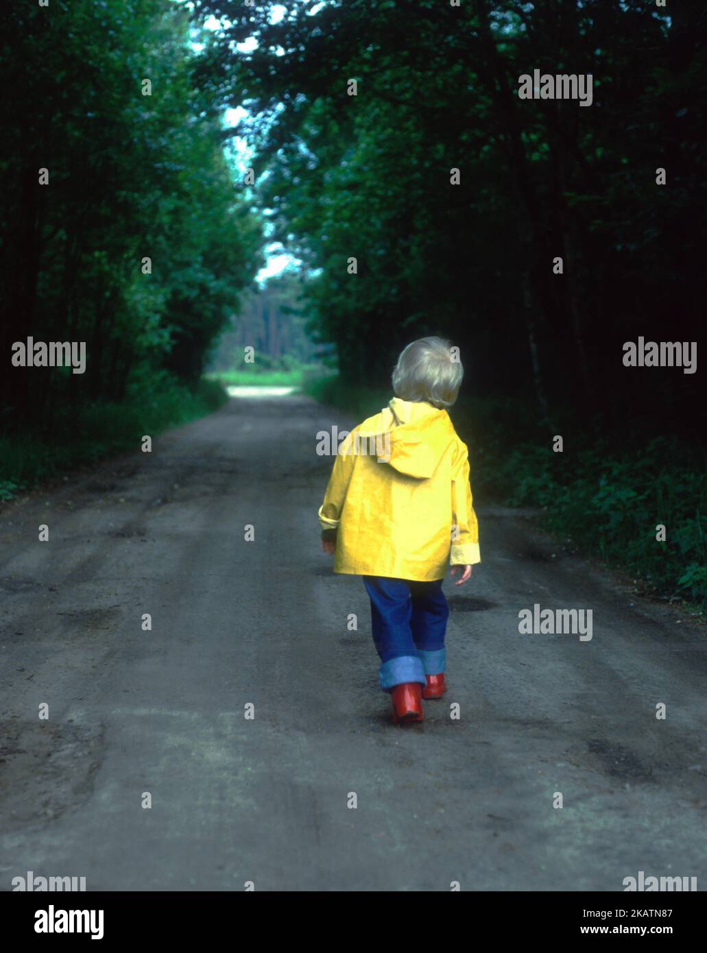 Rückansicht des Jungen, der auf der Landstraße läuft Stockfoto