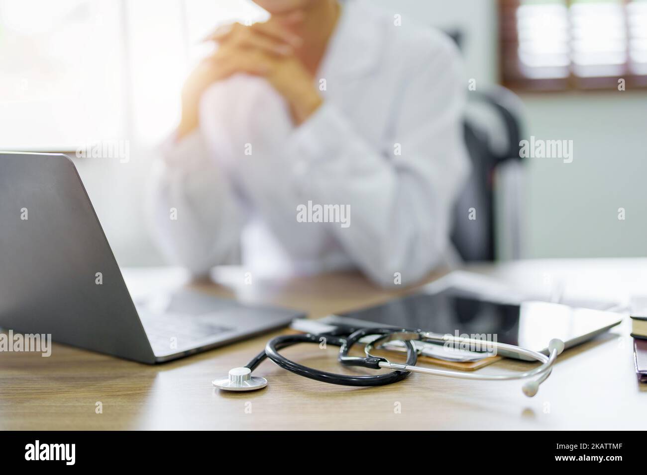 Eine asiatische Ärztin verwendet einen Computer, während sie sich Sorgen um Patienteninformationen macht Stockfoto