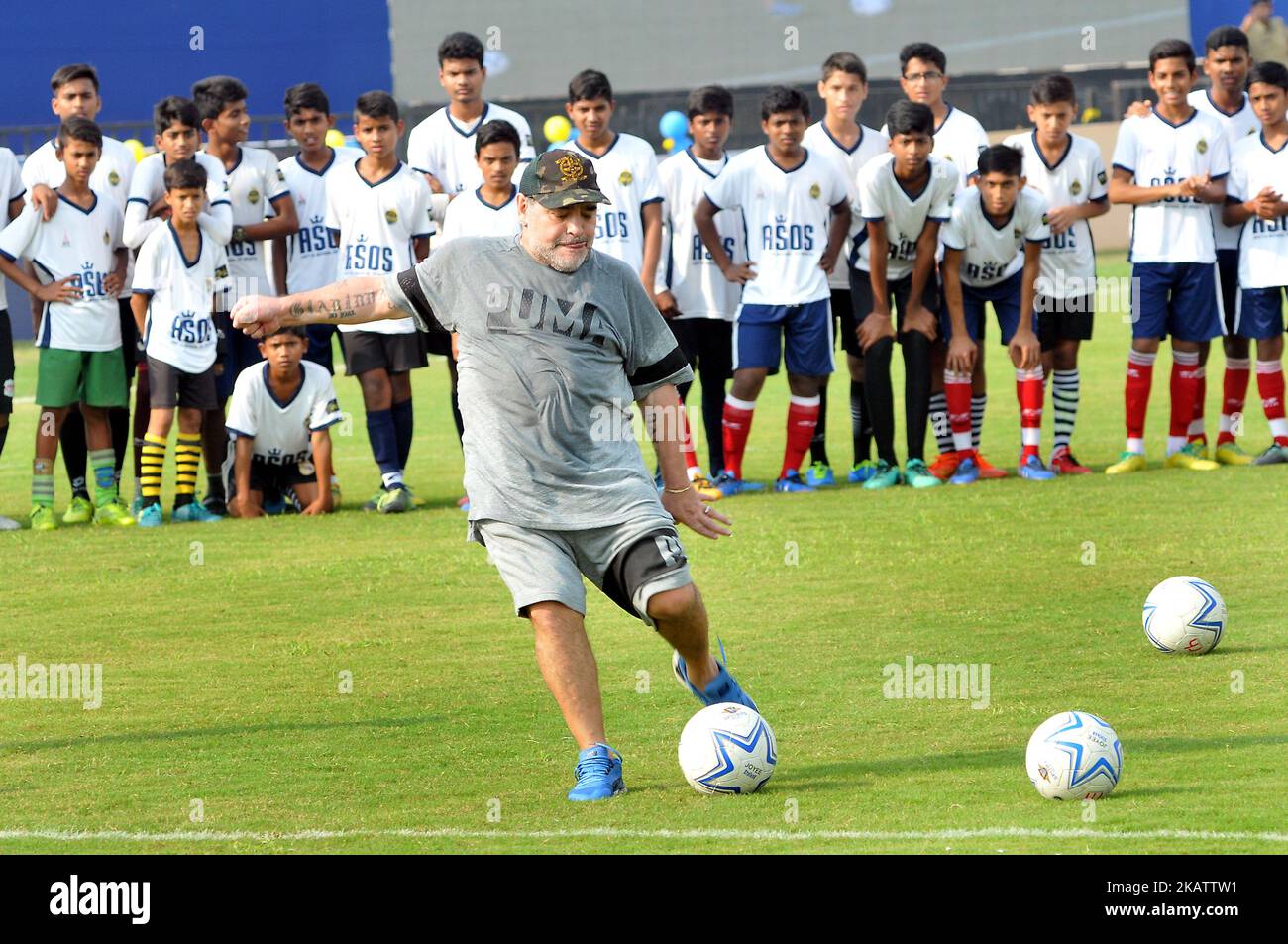 Argentiniens Fußballlegende Diego Maradona tritt am 12. Dezember 2017 in Barasat, etwa 38 km nördlich von Kalkutta, bei einem Fußballworkshop mit Schülern einen Fußball ein, Gesten. Maradona ist zu einem privaten Besuch in Indien.Diego Armando Maradona wurde am 30. Oktober 1960 geboren.während seiner Zeit bei der argentinischen Nationalmannschaft erzielte Maradona 34 Tore bei 91 Auftritten. Sein internationales Debüt feierte er mit 16 Jahren gegen Ungarn am 27. Februar 1977. Maradona wurde von Trainer Cesar Luis Menotti für die Weltmeisterschaft 1978 auf heimischem Boden aus dem argentinischen Kader gelassen, der sich mit 17 Jahren zu jung fühlte.Maradon Stockfoto