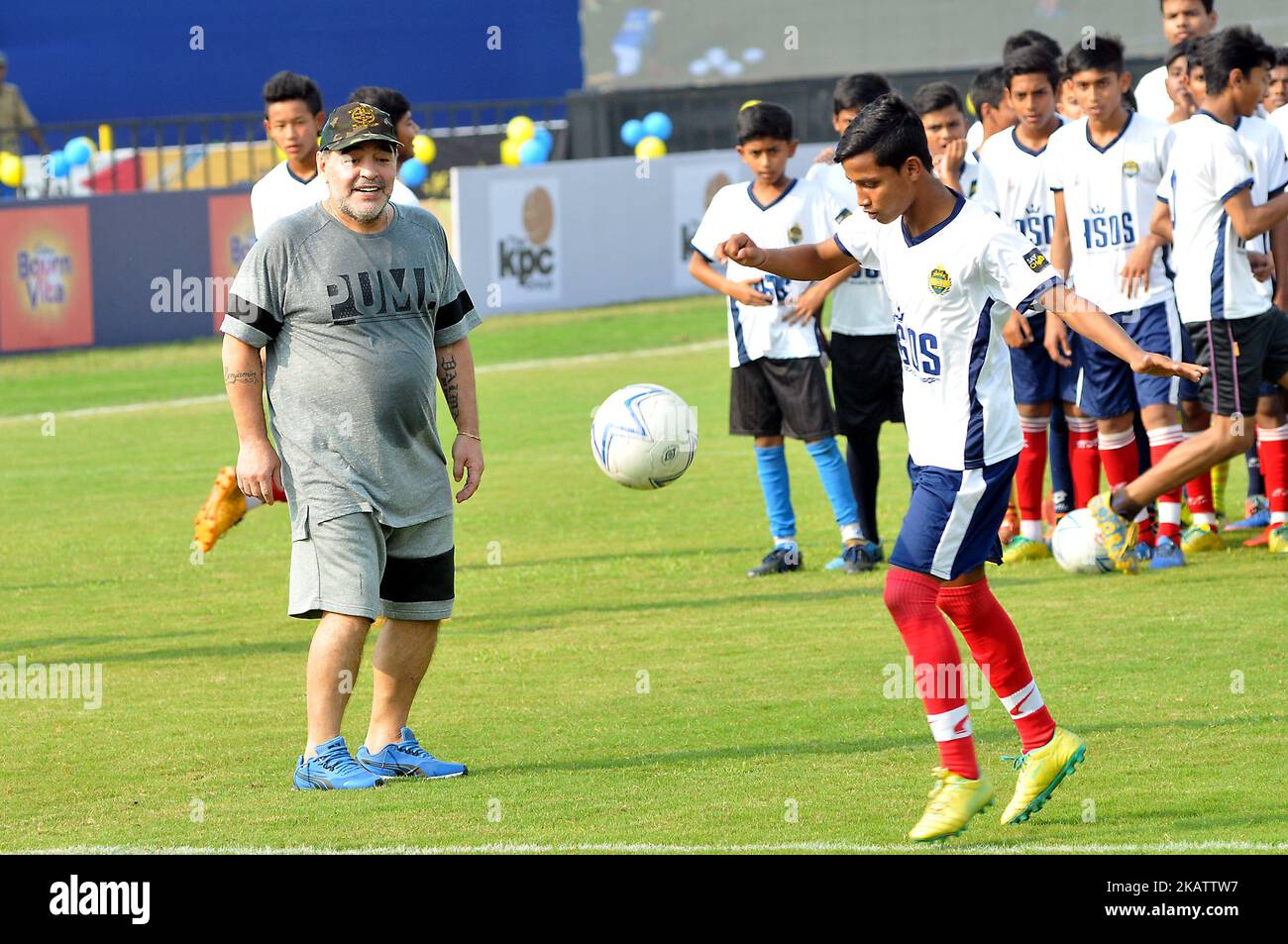 Argentiniens Fußballlegende Diego Maradona tritt am 12. Dezember 2017 in Barasat, etwa 38 km nördlich von Kalkutta, bei einem Fußballworkshop mit Schülern einen Fußball ein, Gesten. Maradona ist zu einem privaten Besuch in Indien.Diego Armando Maradona wurde am 30. Oktober 1960 geboren.während seiner Zeit bei der argentinischen Nationalmannschaft erzielte Maradona 34 Tore bei 91 Auftritten. Sein internationales Debüt feierte er mit 16 Jahren gegen Ungarn am 27. Februar 1977. Maradona wurde von Trainer Cesar Luis Menotti für die Weltmeisterschaft 1978 auf heimischem Boden aus dem argentinischen Kader gelassen, der sich mit 17 Jahren zu jung fühlte.Maradon Stockfoto
