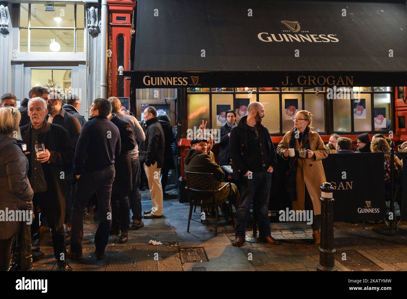 Die Leute genießen einen Drink und plaudern vor dem J.Grogan Pub im Stadtzentrum von Dublin, nur wenige Tage vor Weihnachten. Die 12 weihnachtlichen Pubs haben sich in Irland zu einer jährlichen Tradition entwickelt, in der Gruppen von Freunden im ganzen Land auf Trinkstrecken gehen. Am Donnerstag, den 21. Dezember 2017, in Dublin, Irland. (Foto von Artur Widak/NurPhoto) Stockfoto