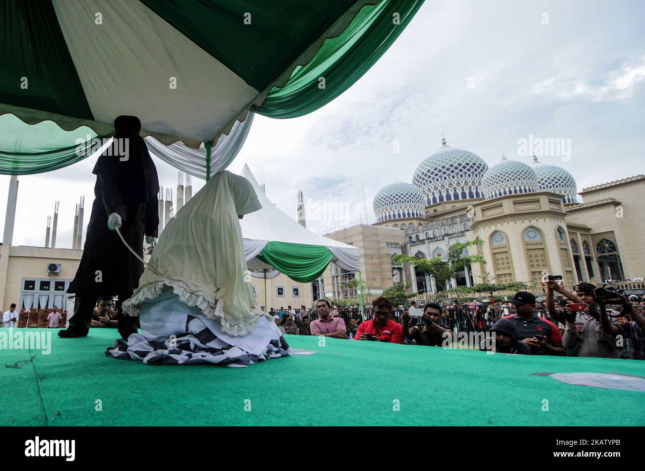 Eine aehnesische Frau wird am 22. Dezember 2017 in der Moschee des Islamischen Zentrums Lhokseumawe in der Provinz Aceh, Indonesien, vor der Öffentlichkeit wegen Verstoßes gegen das Scharia-Gesetz ausgepeitscht. Peitschen ist eine Form der Strafe, die in Aceh für die Verletzung des islamischen Scharia-Gesetzes verhängt wurde. (Foto von Fachrul Reza/NurPhoto) Stockfoto