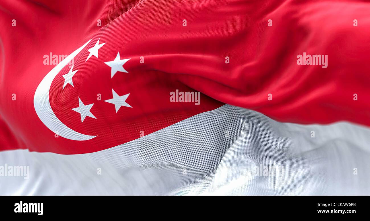 Nahaufnahme des Winkens der Nationalflagge Singapurs. Die Republik Singapur ist ein Stadtstaat Südostasiens. Texturierter Hintergrund aus Stoff. Selektive Stockfoto