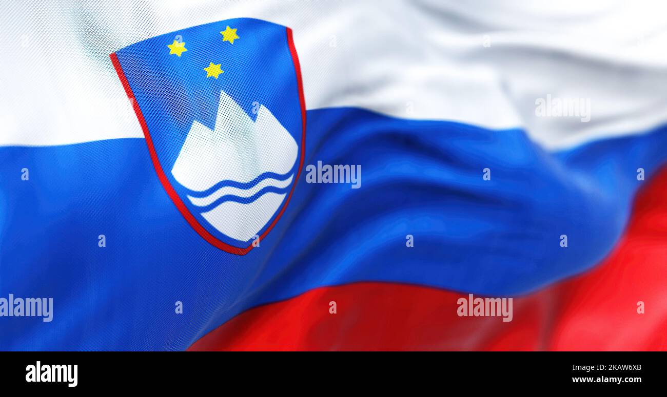 Nahaufnahme des Winkens der slowenischen Nationalflagge. Die Republik Slowenien ist ein souveräner Staat Mitteleuropas. Texturierter Hintergrund aus Stoff. Selektiv Stockfoto