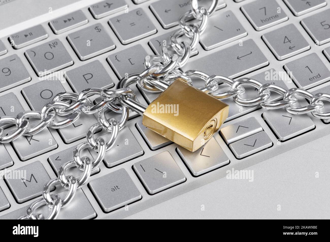 Verriegelte Kette an der Tastatur des Laptops. Cybersicherheit Stockfoto