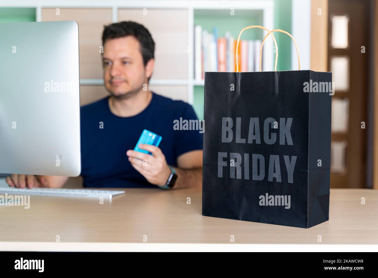 Mann in seinem Heimbüro, der Sachen online für schwarzen freitag kauft Stockfoto
