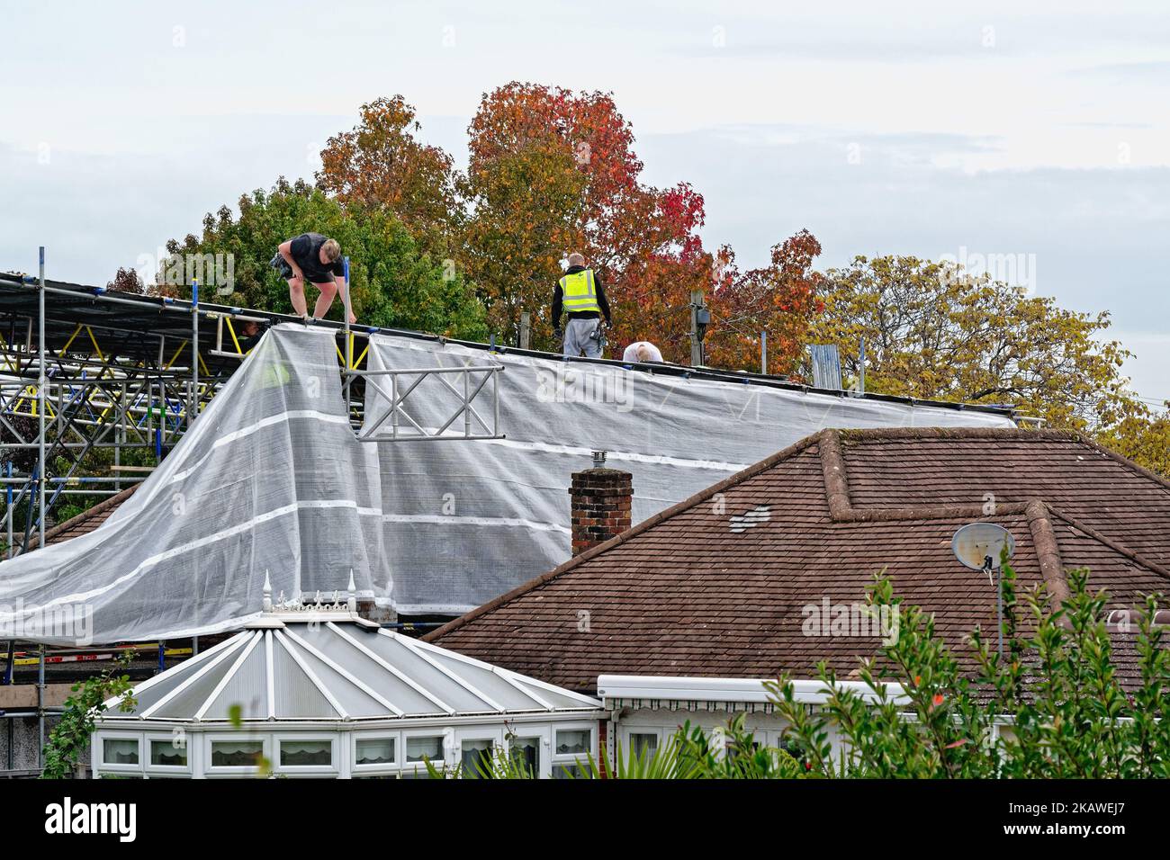 Gerüste, die vor den Bauarbeiten am Dach ein Gerüst auf einem Vorstadtbungalow errichten, Shepperton England, Großbritannien Stockfoto