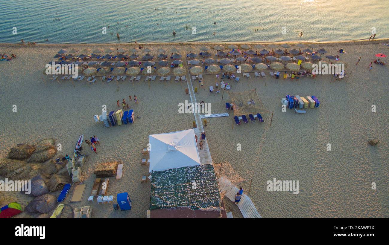 Drohnenaufnahmen am Abend. Des Strandes von Nea Irakleia in Chalkidiki. Der Sandstrand ist einer der längsten zusammenhängenden Strände in Griechenland. Ideal zum Schwimmen, da es goldenen Sand, flaches und glattes Wasser und das Fehlen von Wellen gibt. Der Strand ist leicht von der Hauptstadt Thessaloniki zu erreichen, da er 30km entfernt ist und über eine Autobahn verbunden ist. Etwa 25km vom Flughafen Makedonia in Thessaloniki. Es gibt viele Strandbars, die Ihnen Chillout-Musik, kalten Kaffee, Getränke und Snacks anbieten. Einige der Bars sind "Sunshine", "Sayonara", "Yolo", "La Roca", "Crystal Life" und eine der größten des Landes, "Sahar Stockfoto