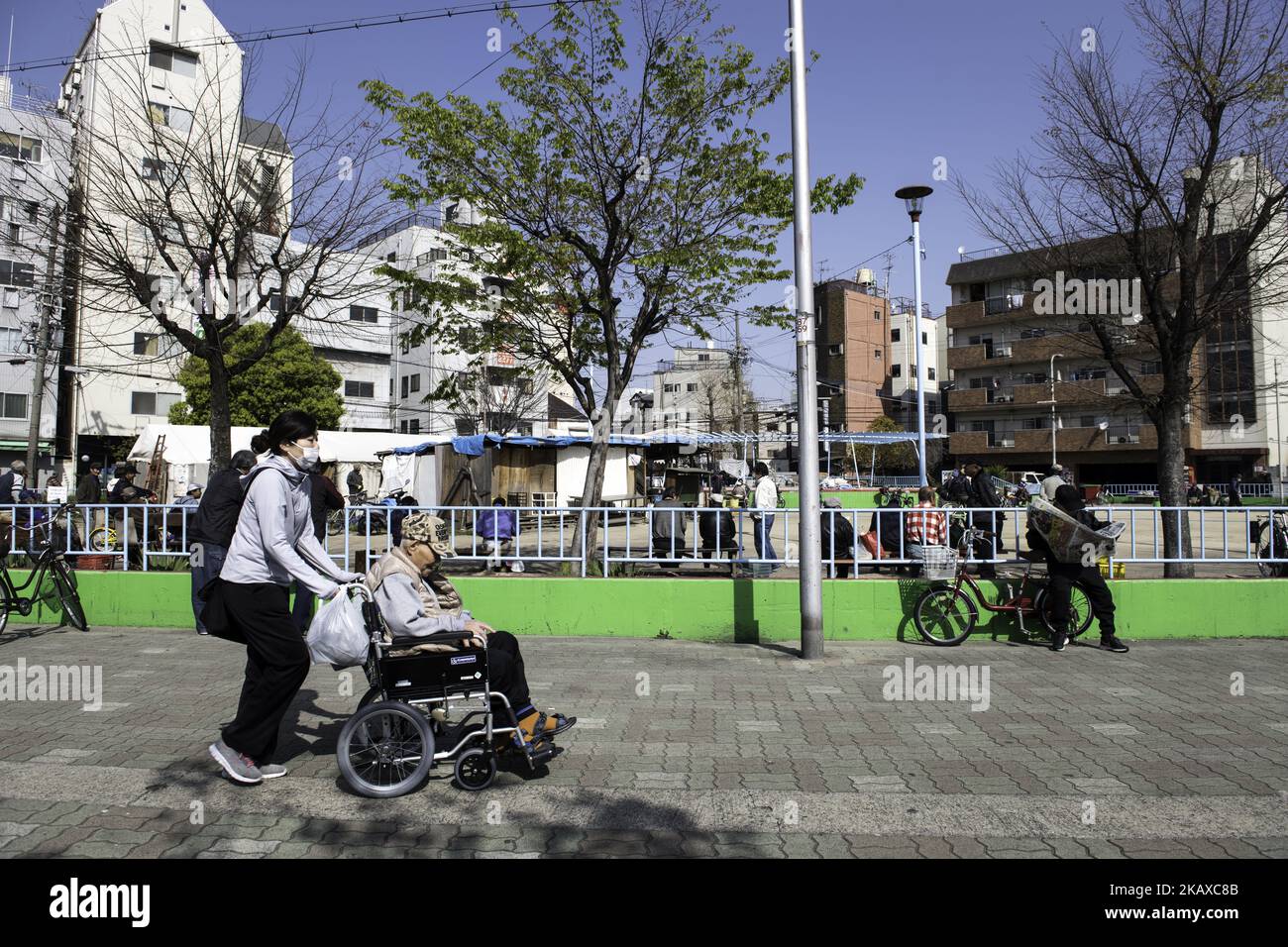 OSAKA, JAPAN - 31. MÄRZ: Obdachlose warten am 31. März 2018 im Sankaku Park, Airin in der Nishinari Station, in einer Gegend, in der eine der größten Obdachlosen- und Tagelöhnerpopulationen des Landes in der Präfektur Osaka, Japan, lebt, auf kostenloses Essen. Japan, die drittgrößte Volkswirtschaft der Welt, war einst stolz darauf, eine allgemein bürgerliche Gesellschaft zu sein und frei von der Armut mit den übrigen reichen Ländern zu sein, aber Tausende versuchten, auf der Straße zu leben, um mit dem Zusammenbruch der Blasenwirtschaft im Jahr 1990s „Homuresu“ zu werden. Das Japans Versprechen, lebenslange, sichere Arbeitsplätze für Unternehmen für al zu schaffen, zunichte gemacht hat Stockfoto