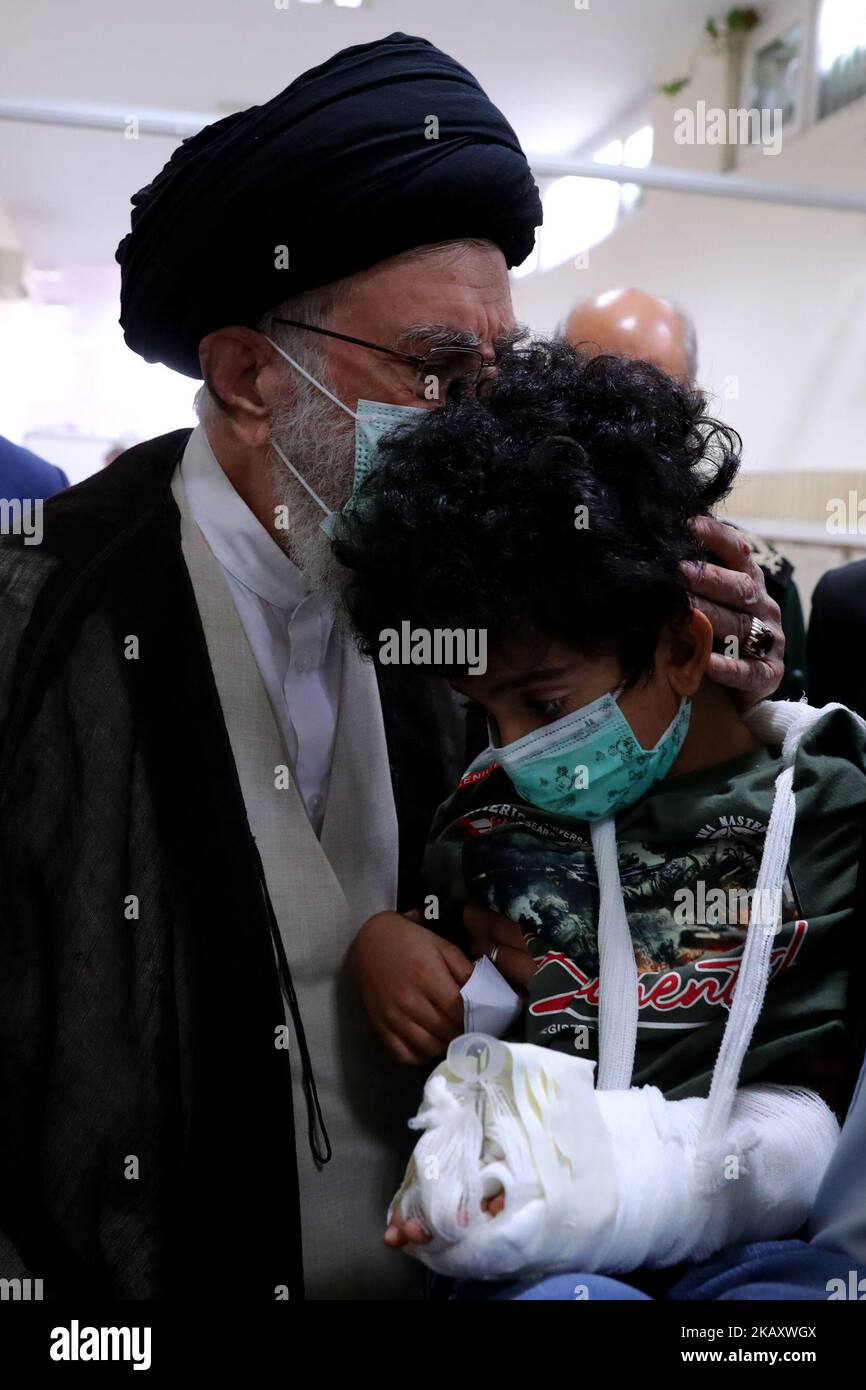 Teheran, Teheran, Iran. 2.. November 2022. Ein Handout-Bild, das vom Büro des iranischen Obersten Führers Ayatollah Ali Khamenei am 2. November 2022 zur Verfügung gestellt wurde, zeigt ihm den Gruß AN ARTIN SERAYEDARAN (R), der seine Eltern bei einem tödlichen Angriff auf das Schah-Cheragh-Mausoleum in der Hauptstadt Teheran verloren hat. Der Führer der Islamischen Revolution, Ayatollah Seyyed Ali Khamenei, sagte, die Vereinigten Staaten hätten keine wichtige Position und sind isoliert in der neuen Weltordnung, die sich herausbildet. (Bild: © Büro des Obersten iranischen Führers über ZUMA Press Wire) Stockfoto