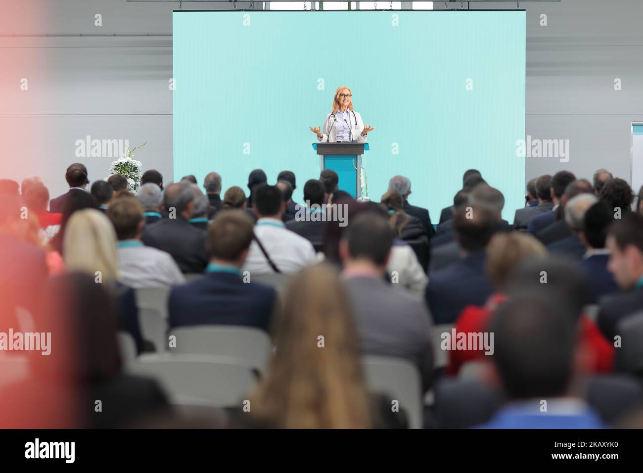 Ärztin, die auf einem Podest vor einem Publikum auf einem medizinischen Kongress eine Rede hält Stockfoto