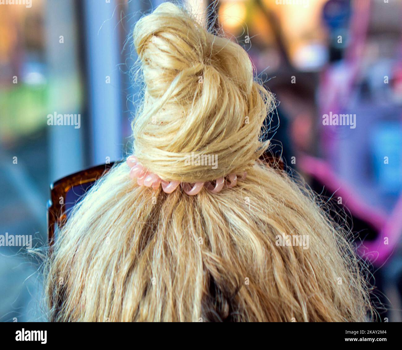 Blonde Haare auf einem Brötchen auf dem Kopf gebunden Stockfoto