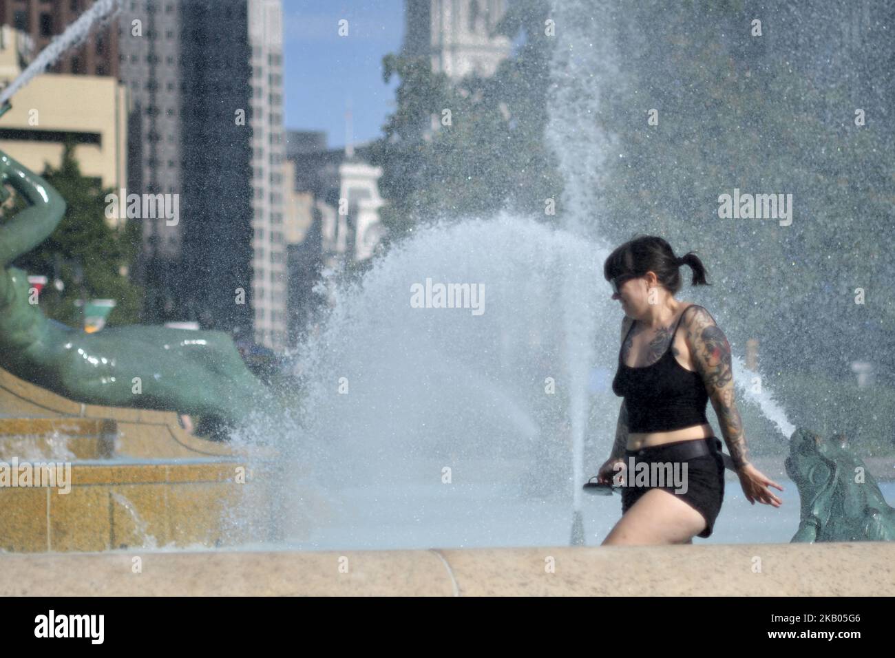 Frau geht durch das Wasser, während die Leute zum Brunnen des Logan Square kommen, um die Hitze eines schönen Sommertages zu schlagen, am 20. Juli 2018 in Philadelphia, PA. (Foto von Bastiaan Slabbers/NurPhoto) Stockfoto