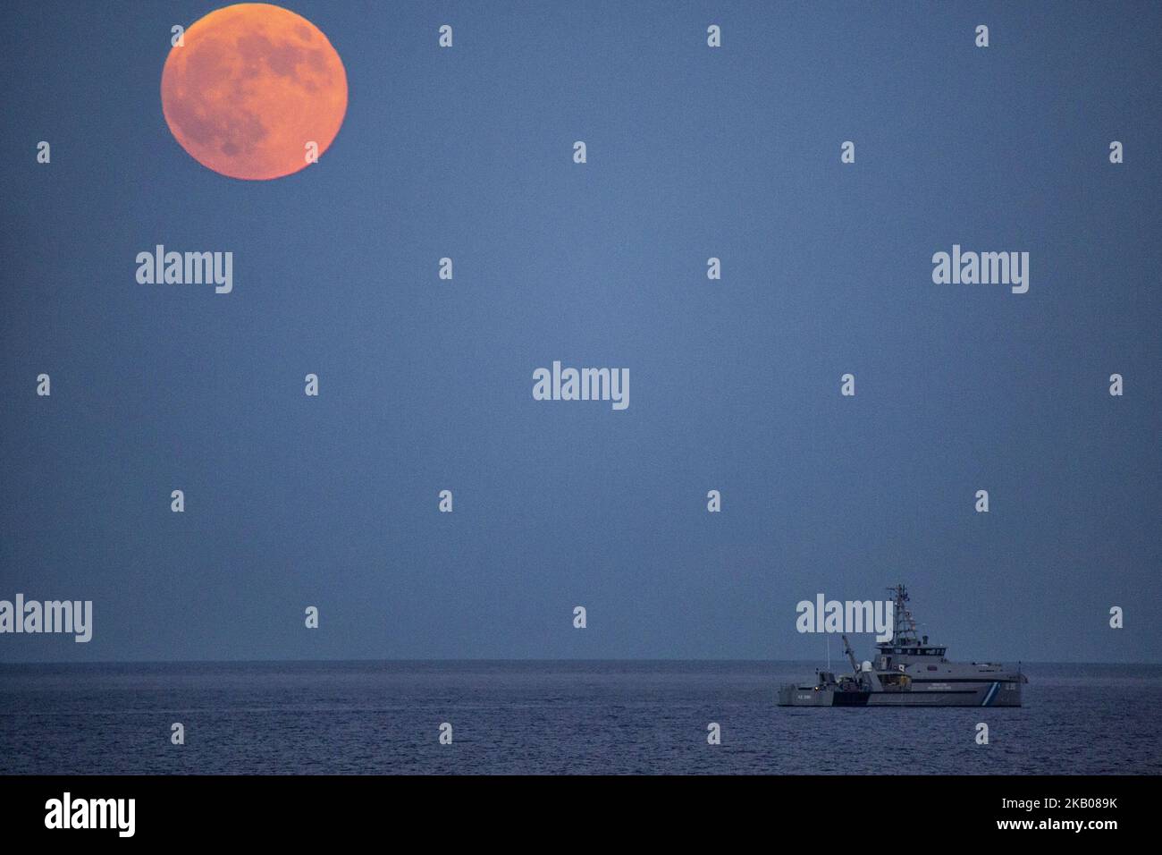 Der „Blutmond“ vor und während der Mondfinsternis im verwüsteten, aus dem Feuer stammenden Gebiet namens Mati in der Nähe von Athen. Das Schiff gehört der Küstenwache, da sie immer noch nach Menschen suchen. Die Finsternis ist die längste totale Mondfinsternis des Jahrhunderts, die einen Blutmond während eines Vollmondes zeigt 27. Juli 2018 - Mati, Attica - Griechenland (Foto von Nicolas Economou/NurPhoto) Stockfoto
