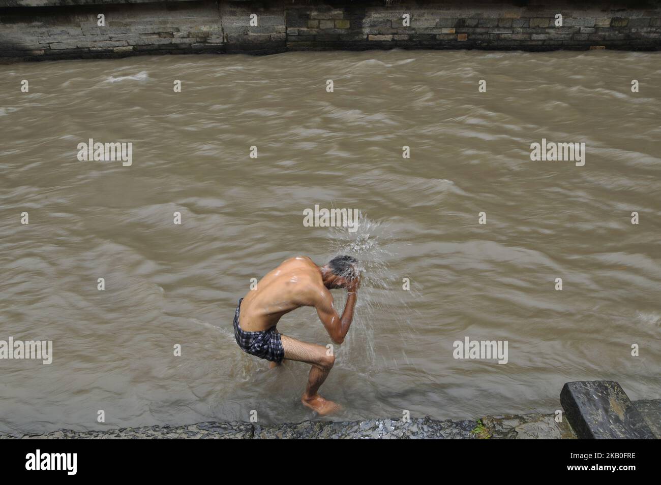 Ein nepalesischer Anhänger nimmt ein Bad im Fluss Bagmati, bevor er „Doro“ während des Janai Purnima Festivals oder Rakchhya Bandhan im Pashupatinath Tempel, Kathmandu, Nepal, am Sonntag, den 26. August 2018, zu einem heiligen bunten Faden wechselt. Während Janai Purnima oder Rakchhya Bandhan ändern Menschen aus der Bhraman- und Chhetri-Gemeinschaft ihren „Janai“ (einen verängstigten Faden). Ebenso werden Menschen aus anderen Gemeinschaften mit einem „Doro“ (einem heiligen bunten Faden) um ihren Rest gebunden. Es wird angenommen, dass dieser Faden Menschen vor Krankheiten und Unglück schützt. Menschen aus Terai und Indien feiern dieses Fest auch als Rakchhya Bandhan. S Stockfoto