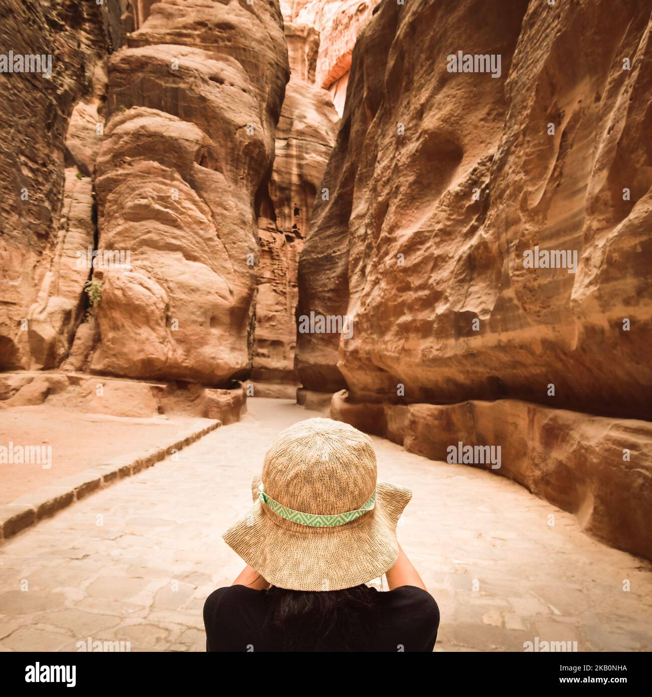 Touristen in Petra fotografieren den Siq, den schmalen Slot-Canyon, der als Eingangstor zur versteckten Stadt Petra, Jordanien, dient Stockfoto