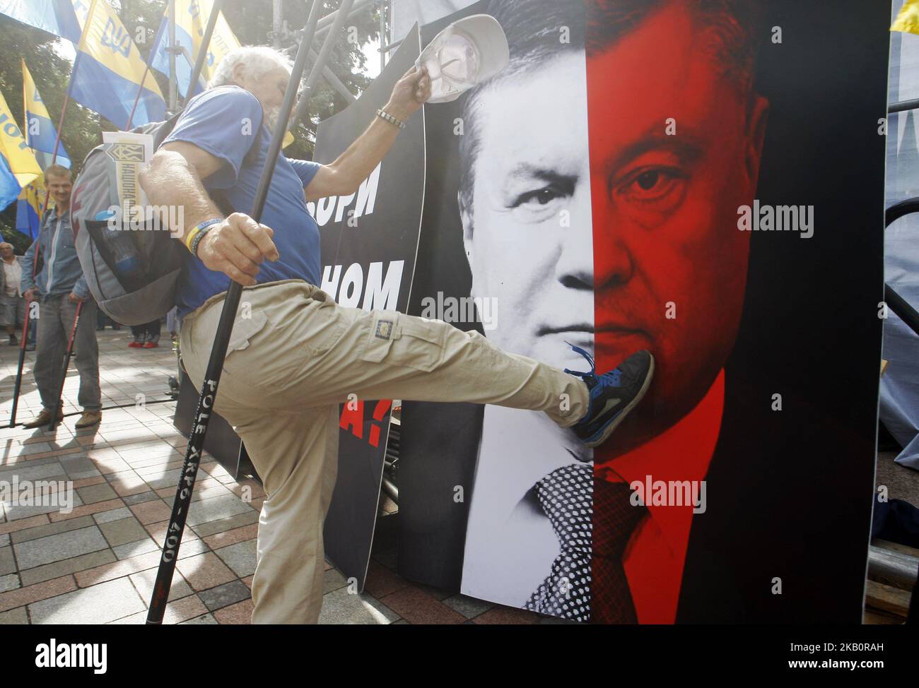 Ein ukrainischer Protestler schlägt ein Plakat mit einem Combo-Portrait, das Gesichter des ukrainischen Präsidenten Poroschenko und des ehemaligen Präsidenten Viktor Janukowitsch während einer Wahlreformkundgebung vor dem ukrainischen Parlamentsgebäude in Kiew, Ukraine, am 06. September 2018 darstellt. Protestierenden, die die Gesetzgeber dazu auffordern, für neue Wahlgesetze zu stimmen. (Foto von NurPhoto) Stockfoto