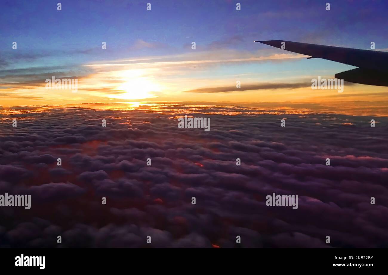 Sonnenuntergang über den Wolken mit Flugzeugflügel Stockfoto