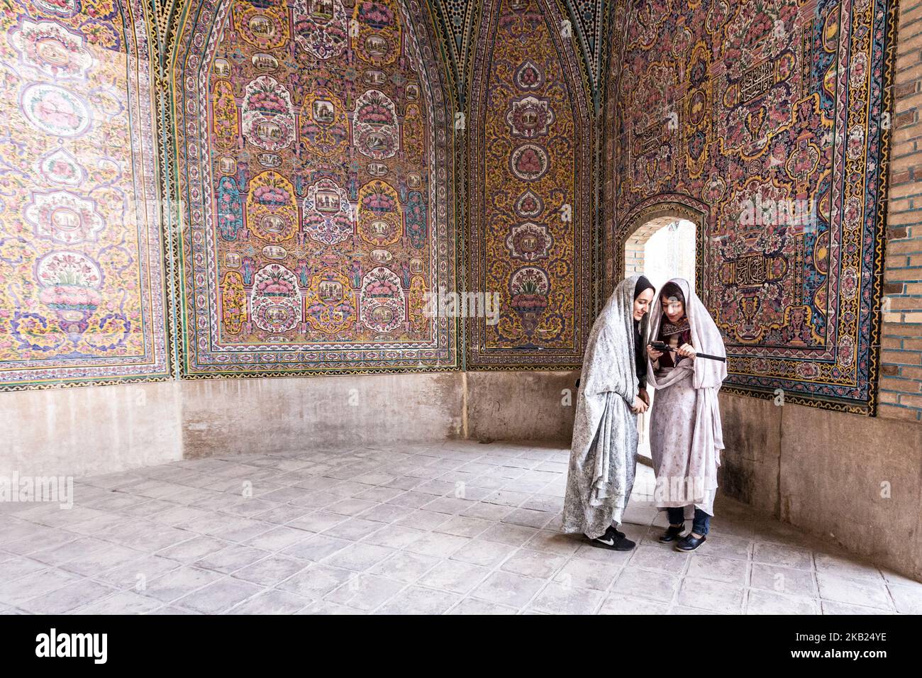 Iranische junge Frauen sprechen auf einem Hof der Nasir-al-Mulk-Moschee, auch die Rosa Moschee genannt, in Shiraz, Iran, 15. September 2018. (Foto von Dominika Zarzycka/NurPhoto) Stockfoto