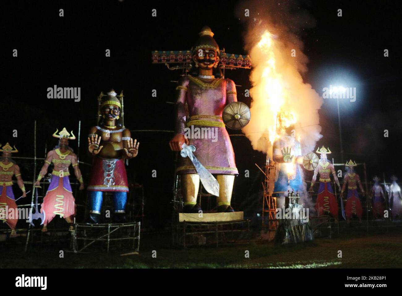 Indische hinduistische Anhänger beobachten ein Bildnis des hinduistischen Dämonenkönigs Ravana, gefüllt mit Feuerwerkskörpern, das am 19. Oktober 2018 anlässlich des Hindu-Festivals von Dussehra in Kalkutta brennt. Dussehra, das am Ende des Navratri-Festivals (neun Nächte) stattfindet, symbolisiert den Sieg des Guten über das Böse in der hinduistischen Mythologie. Während der Dussehra-Nacht werden Feuerwerkskörper und ausgestopfte Bildnis von Ravana auf offenem Gelände im ganzen Land angezündet. (Foto von Debajyoti Chakraborty/NurPhoto) Stockfoto