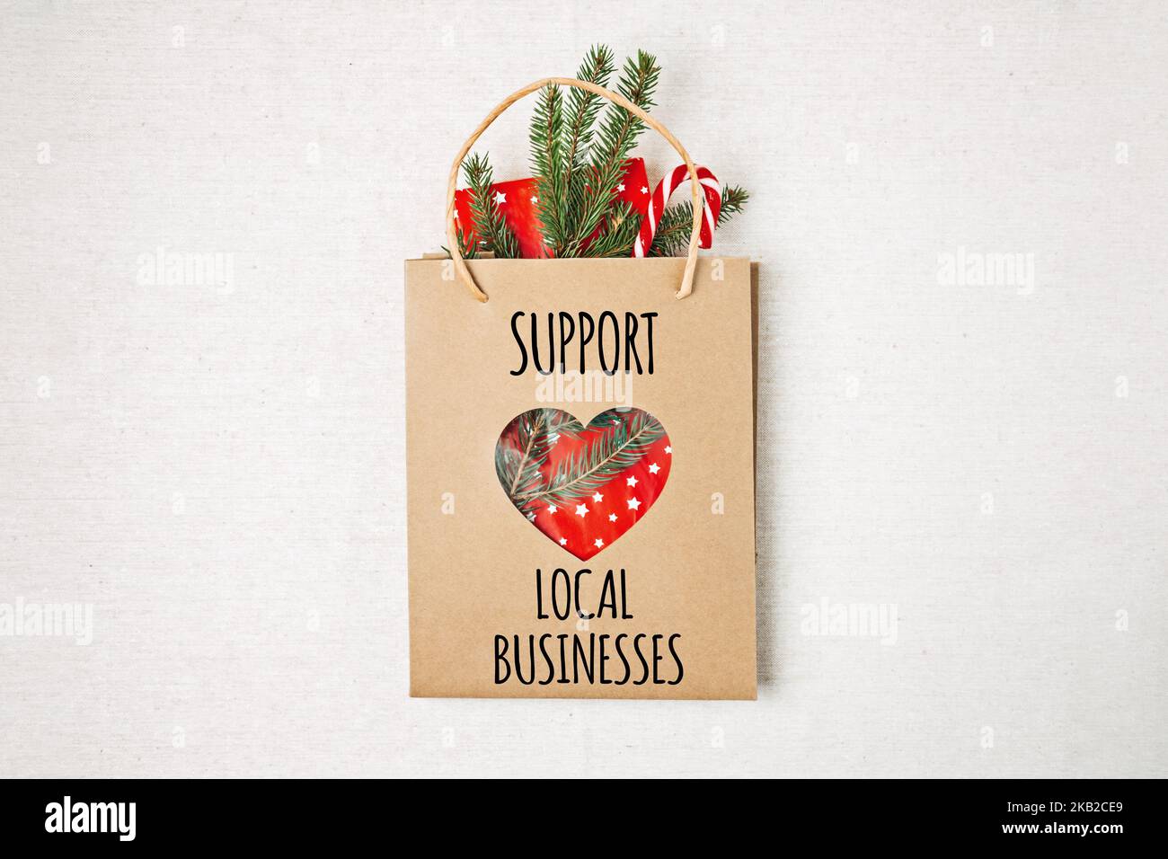 Support Local Business Text auf Papier Einkaufstasche geschrieben. Flaches Lay mit Support Local Business Zitat, Weihnachtsdekoration und Einkaufstasche, Geschenk Stockfoto