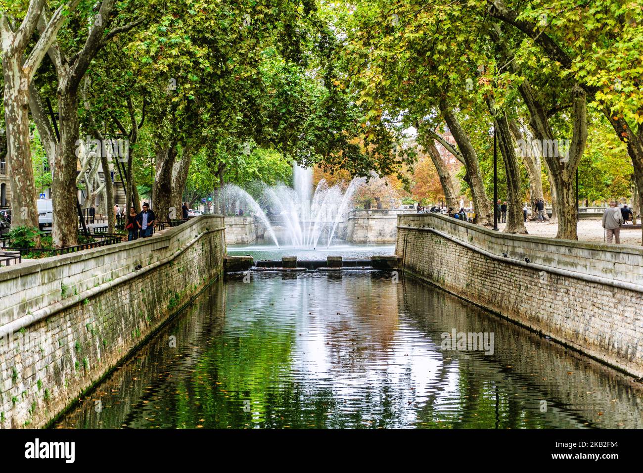 Ein Brunnen und ein Springbrunnen im Jardin de la Fountaine in Nímes, Frankreich. Stockfoto