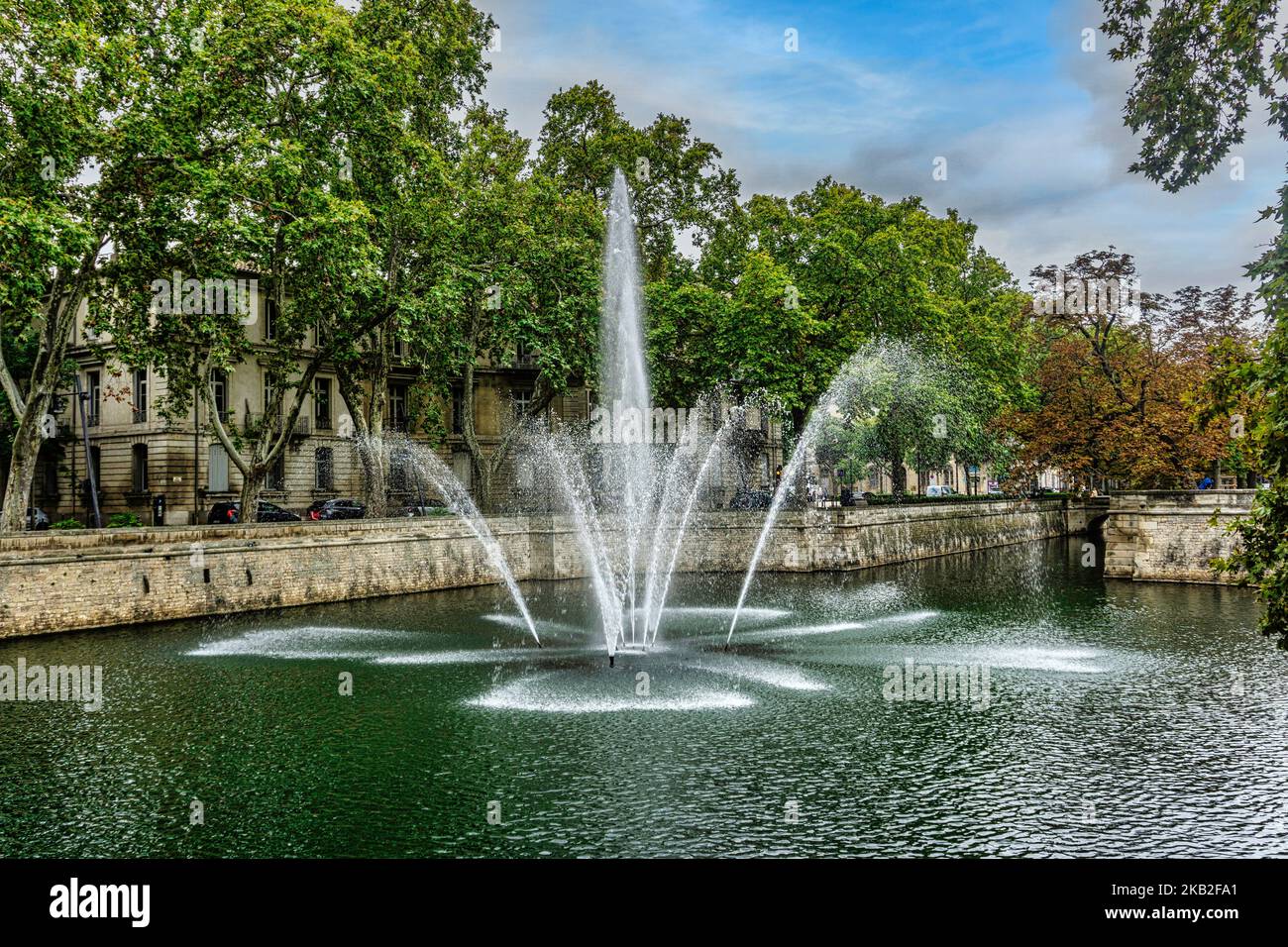 Ein Brunnen und ein Springbrunnen im Jardin de la Fountaine in Nímes, Frankreich. Stockfoto