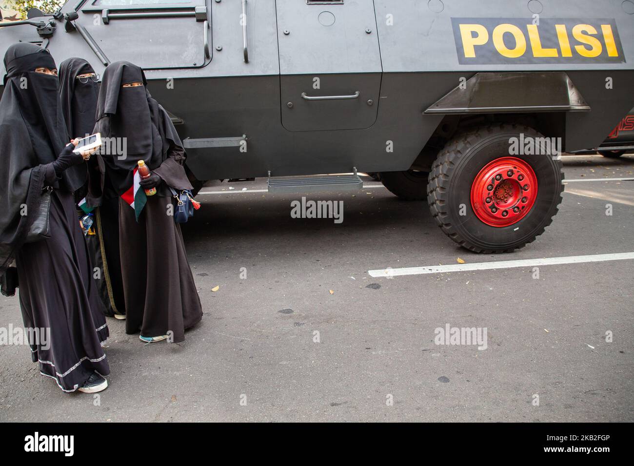 Jakarta, Indonesien, 26. Oktober 2018: Drei muslimische Frauen nach der Demonstration vor dem Polizeiauto. Tausende von Muslimen in Indonesien versammelten sich vor dem indonesischen Koordinator für Politik, Recht und Verteidigung in Jalan Merdeka Barat-Jakarta. Sie protestieren gegen die Aktion einer anderen muslimischen Organisation namens Nahdatul Ulama mit ihrer Unterwerfung Organisation namens 'Banser' (Barisan Ansor Serbaguna), die die Flagge des Islam verbrennt, die 'La Illah ha illallah Muhammaddurrasulullah' schrieb (Es gibt keinen Gott außer Alloh und Muhammad ist der Gesandte von Alloh) Während des Santri National Day Stockfoto