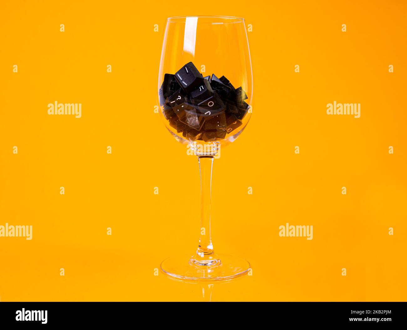 Tastatur-Taste in Glas in Eimer auf orangefarbenem Hintergrund isoliert Hacker Stockfoto