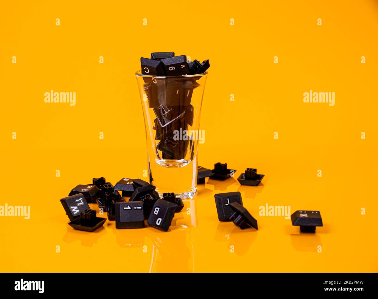 Tastatur-Taste in Glas in Eimer auf orangefarbenem Hintergrund isoliert Hacker Stockfoto