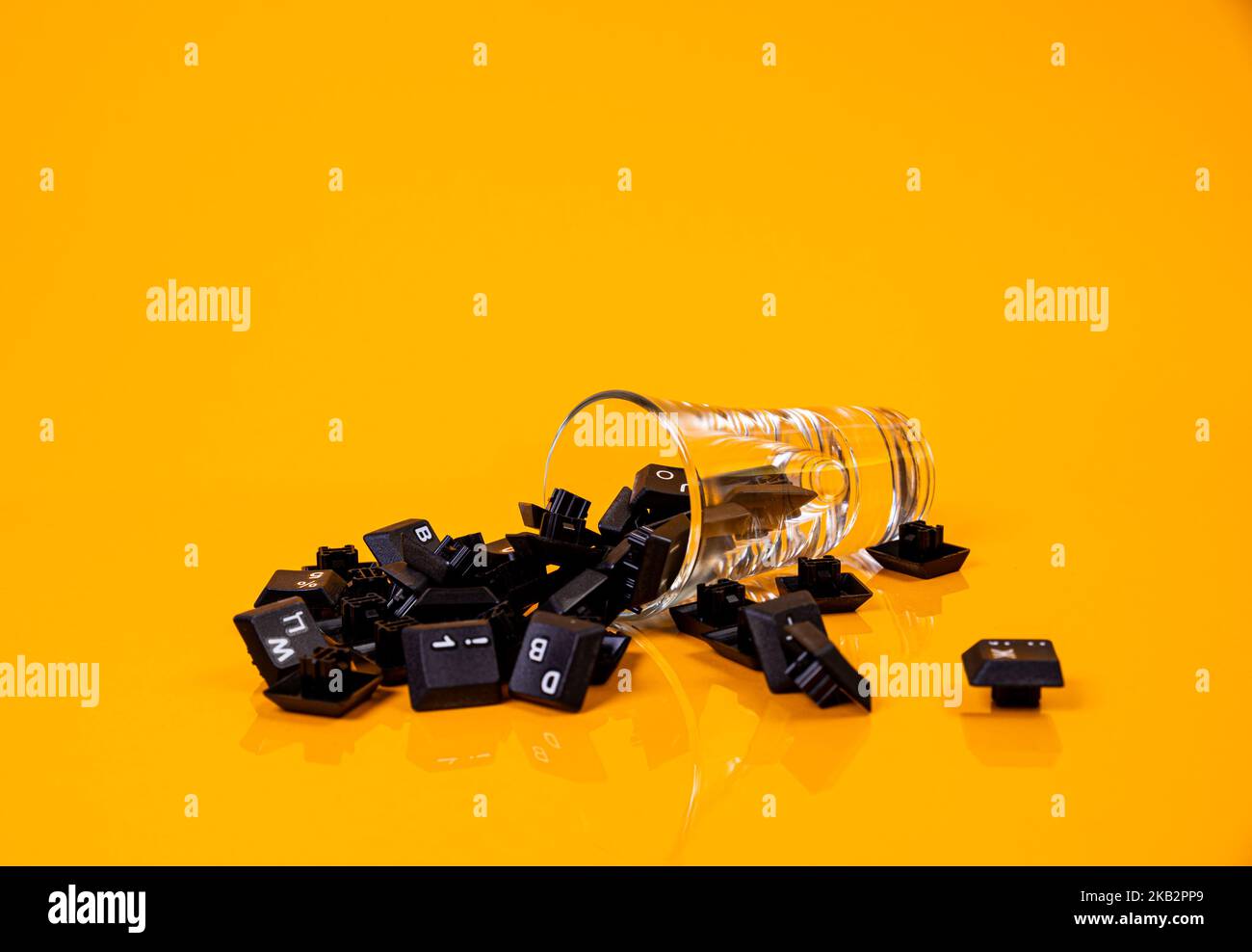 Tastatur-Taste in Glas in Eimer auf orangefarbenem Hintergrund isoliert Hacker Stockfoto