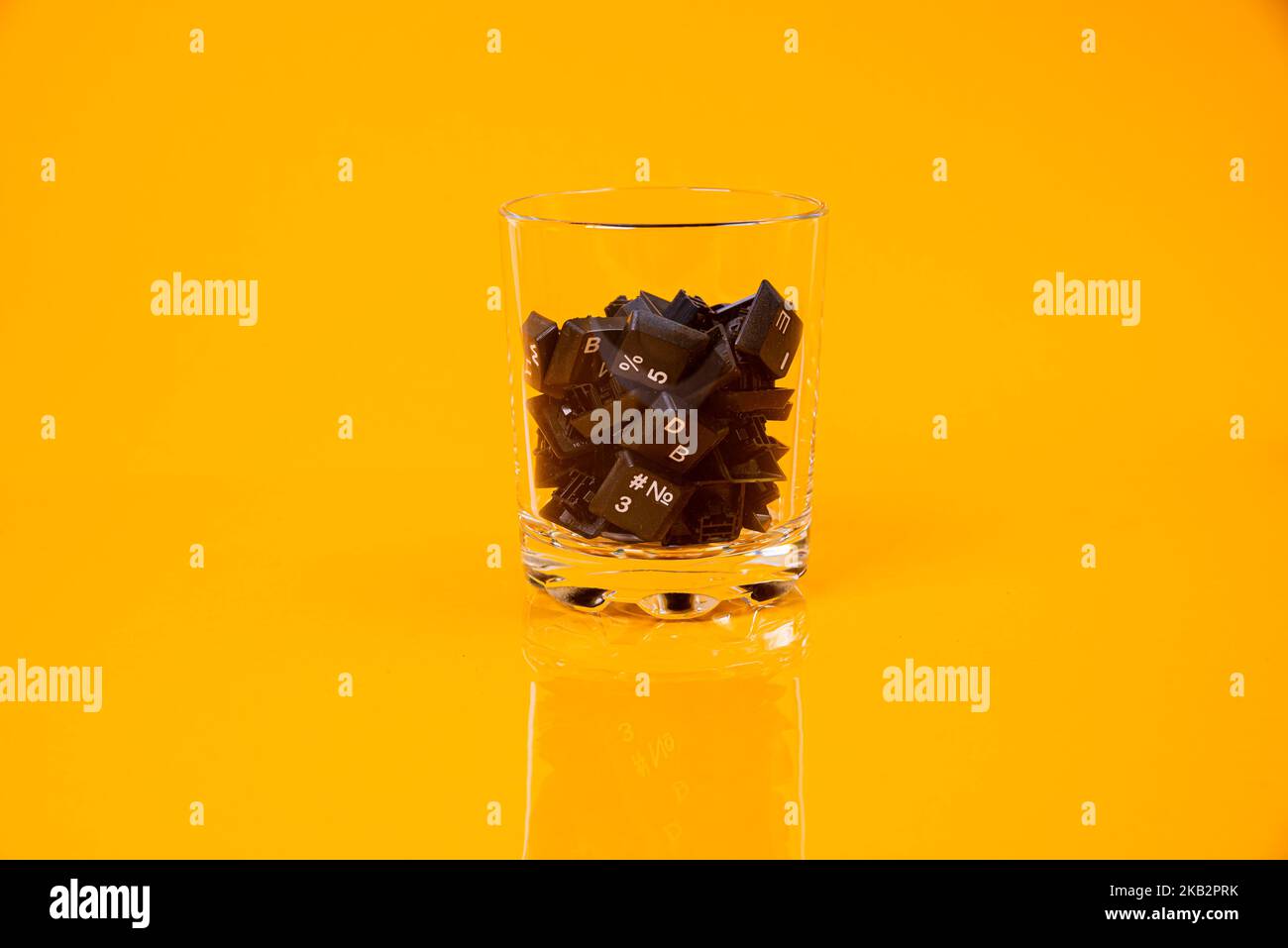 Tastatur-Taste in Glas in Eimer auf orangefarbenem Hintergrund isoliert Hacker Stockfoto