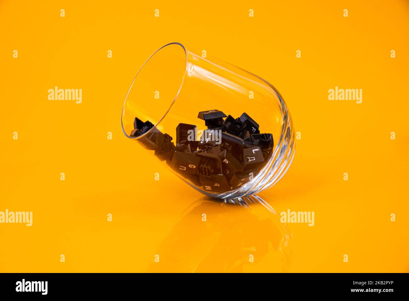 Tastatur-Taste in Glas in Eimer auf orangefarbenem Hintergrund isoliert Hacker Stockfoto