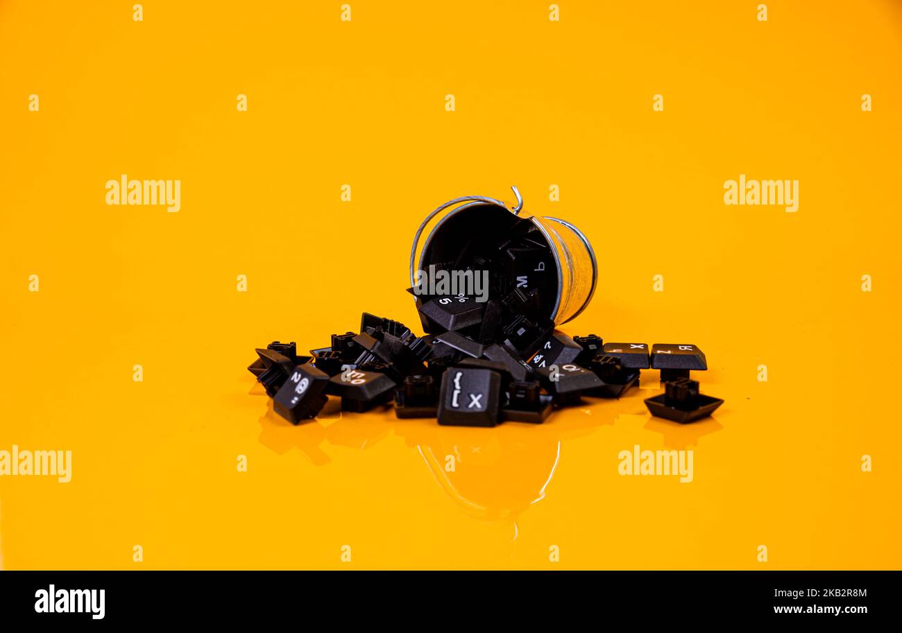 Tastatur-Taste in Glas in Eimer auf orangefarbenem Hintergrund isoliert Hacker Stockfoto