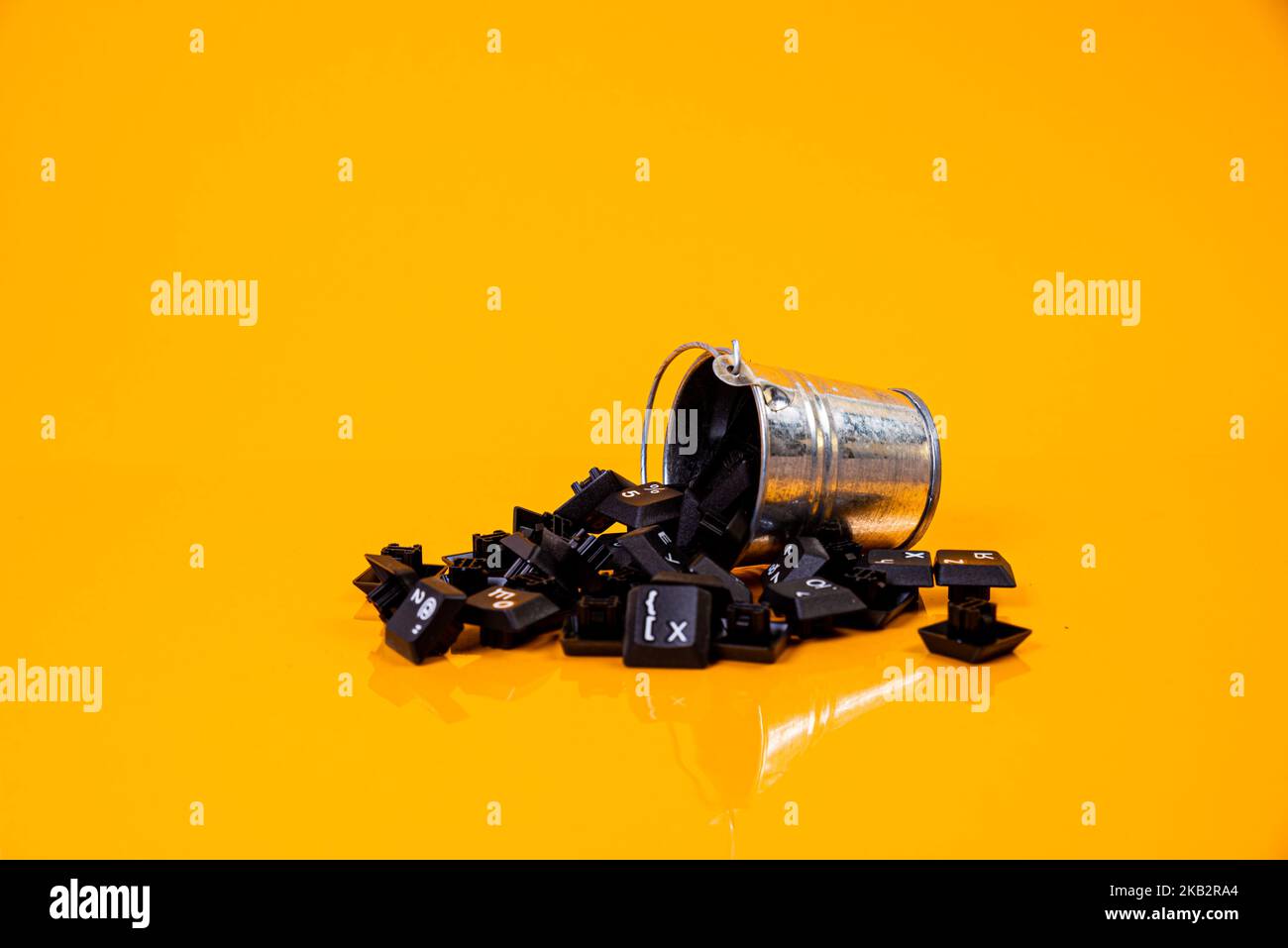 Tastatur-Taste in Glas in Eimer auf orangefarbenem Hintergrund isoliert Hacker Stockfoto